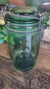 Green glass jar with metal lid on a wooden surface