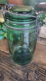 Green glass jar with metal lid on a wooden surface